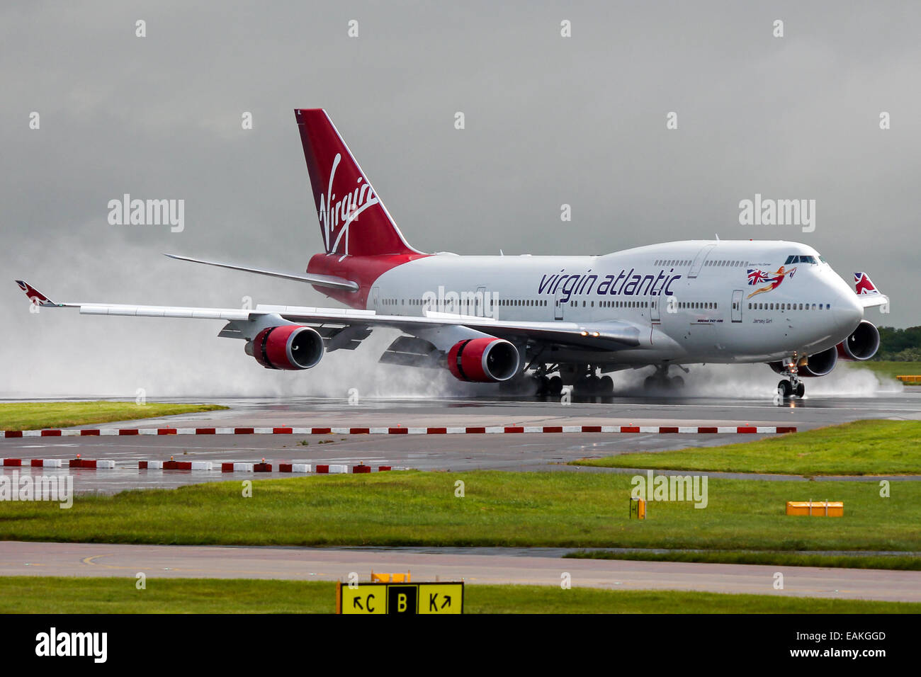 Virgin Atlantic Boeing 747-400 decelerates on runway 23R after a heavy rain shower at Manchester Airport. Stock Photo
