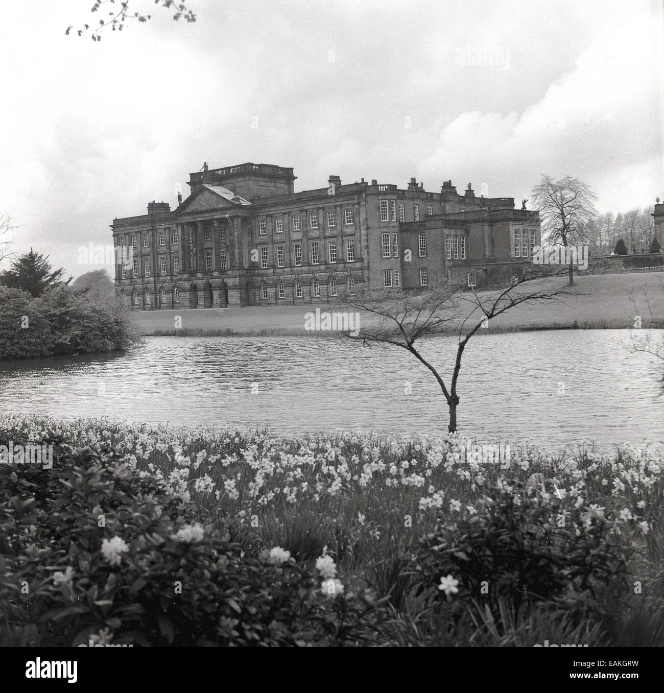 1950s, historical view of the South front of Lyme House, Disley, Cheshire, England, showing lawn and lake. Stock Photo