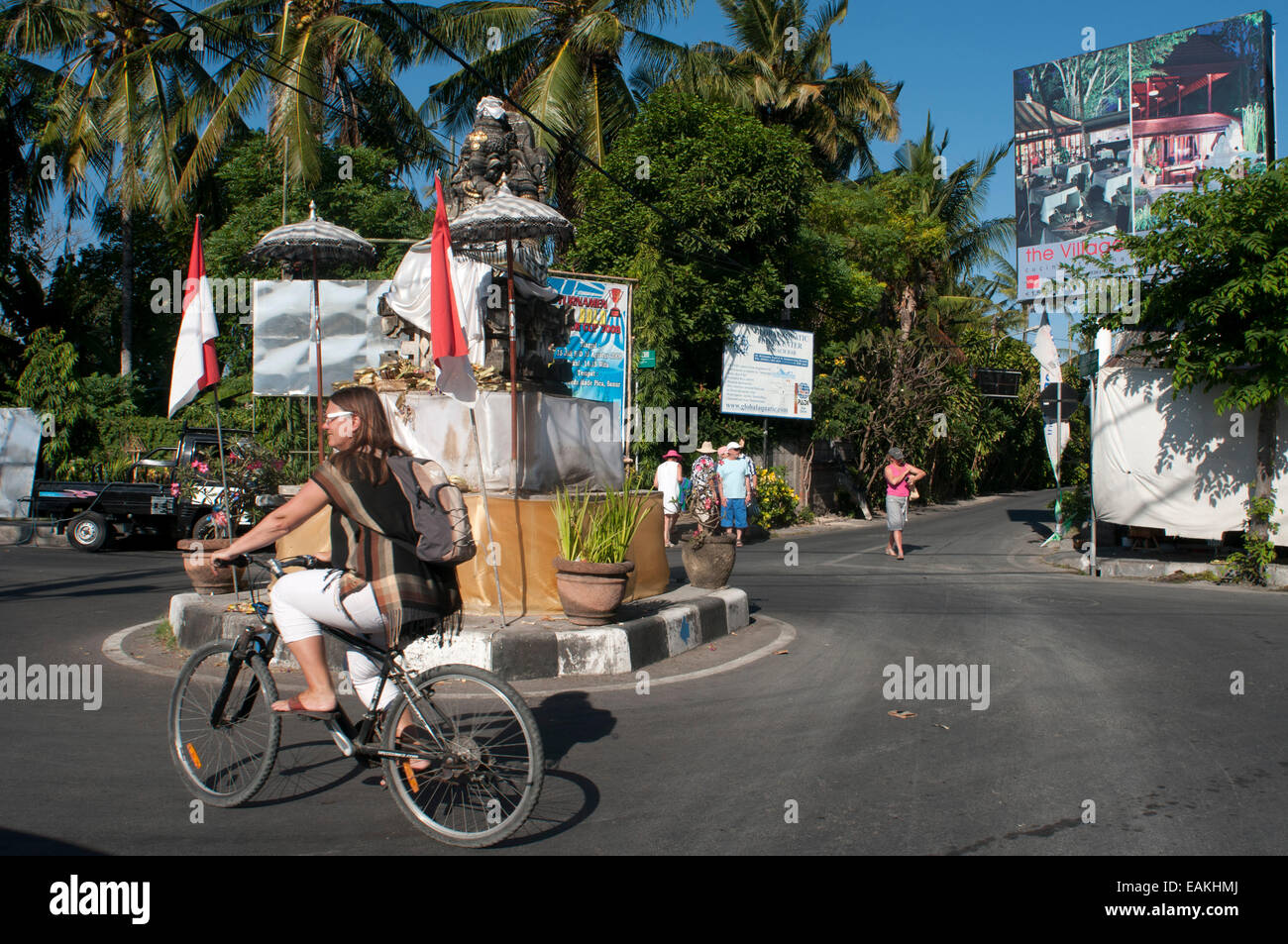 A tourist by bicycle in Kuta street. Surfboard in the streets of Kuta Beach. Bali. Most of Lombok's south coasts offer surf-seek Stock Photo