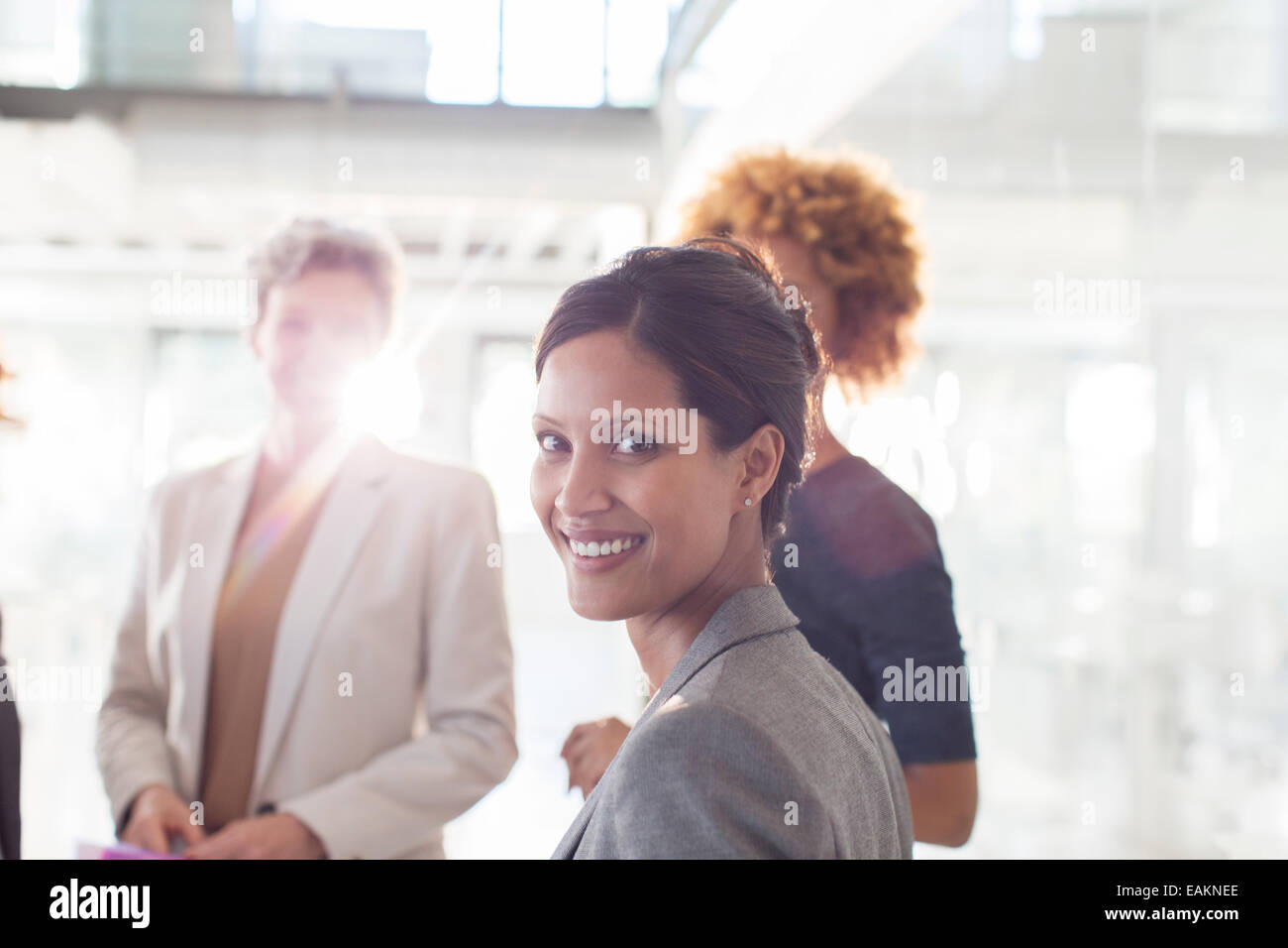 Portrait of smiling businesswoman with colleagues in background Stock Photo