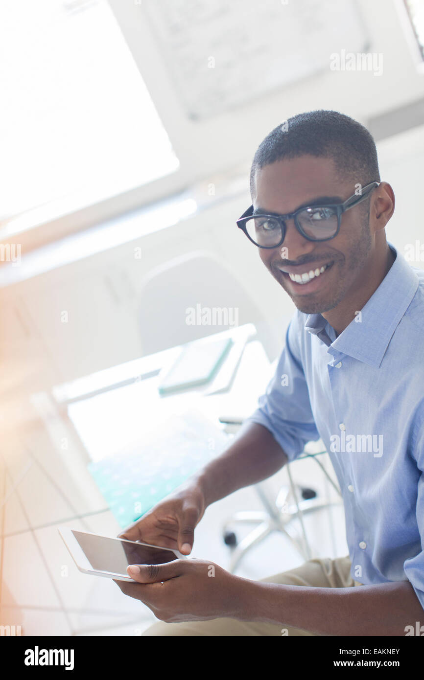 Portrait of smiling young businessman using smart phone in office Stock ...