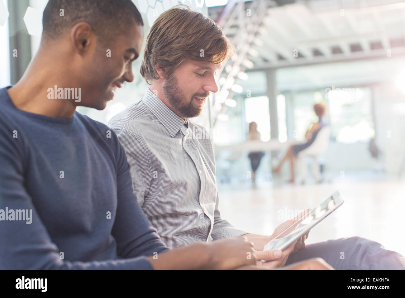 Two smiling businessmen using digital tablet in office Stock Photo