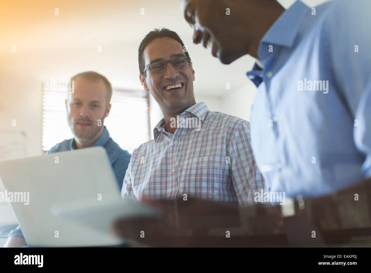 Men using digital tablet and laptop in office Stock Photo