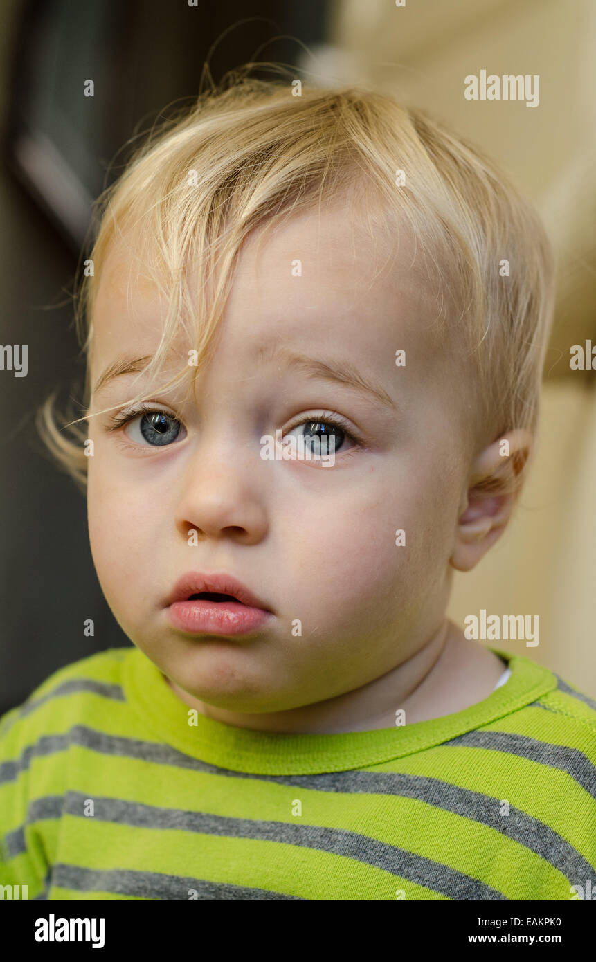 A pensive-looking blond and blue-eyed baby boy (ca. 18 months old). Stock Photo