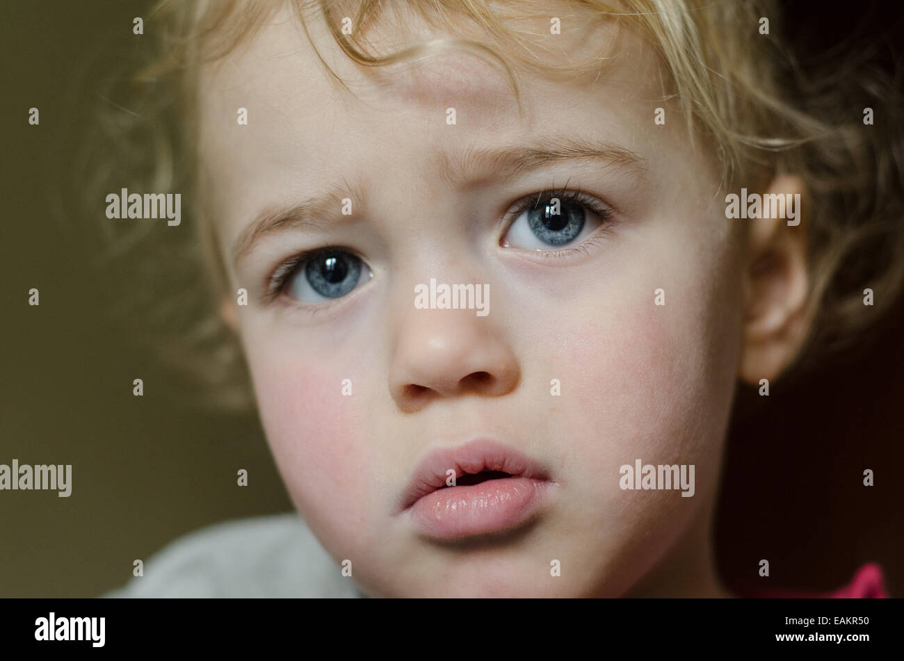 A serious-looking blonde and blue-eyed baby boy (ca. 20 months old). Stock Photo