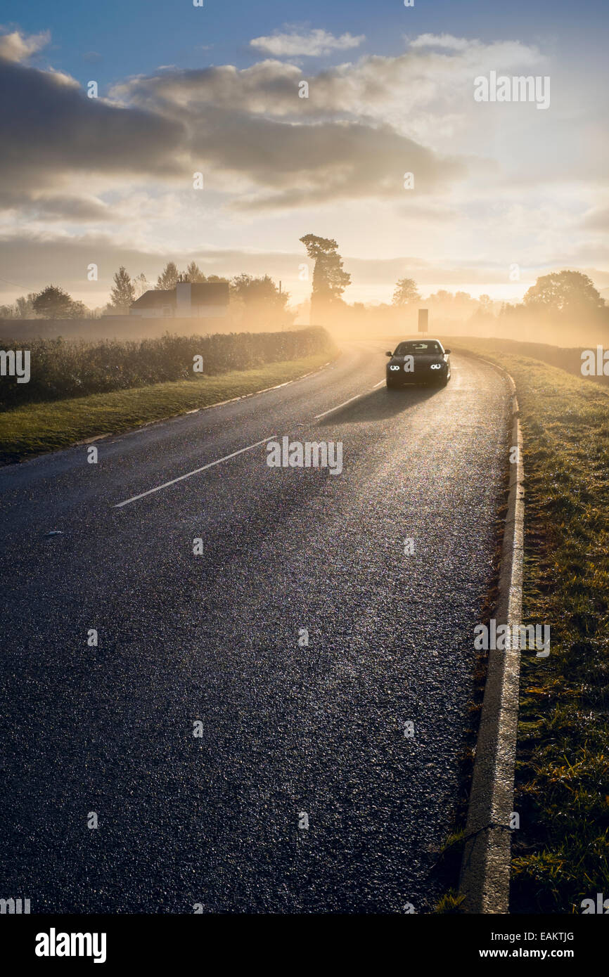 Car travelling along  a foggy country road. Stock Photo
