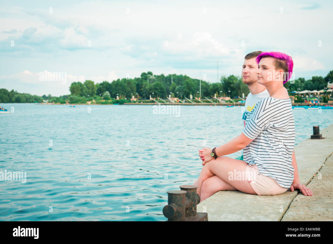 Man and woman sitting in the evening on the river bank Stock Photo - Alamy