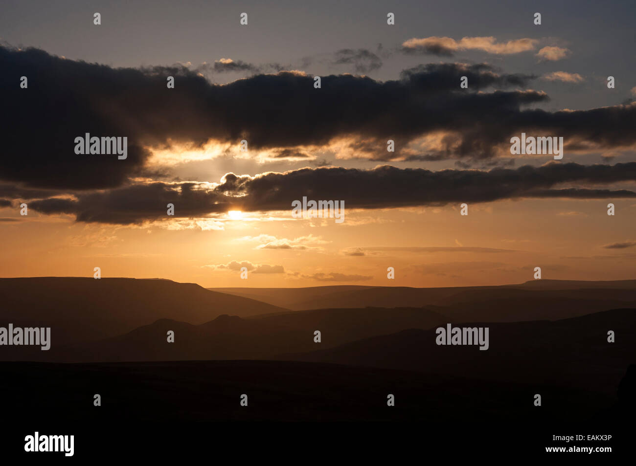 Beautiful sunset as seen from Stanage Edge in the Peak District, Derbyshire. Sun hiding behind a bank of cloud. Stock Photo