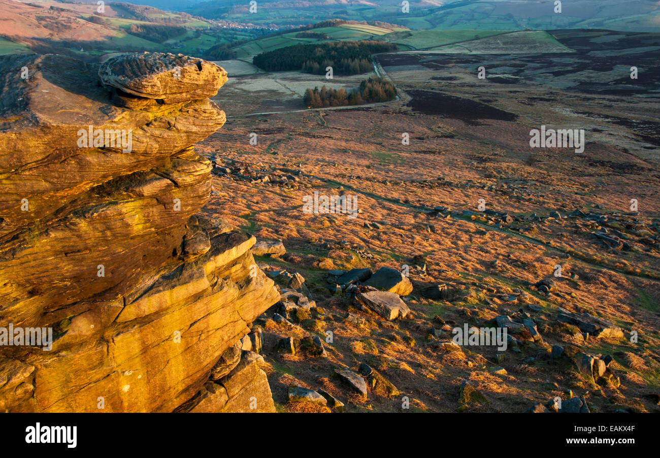 View from Stanage Edge at dusk with golden glow on gritstone rocks. Stock Photo