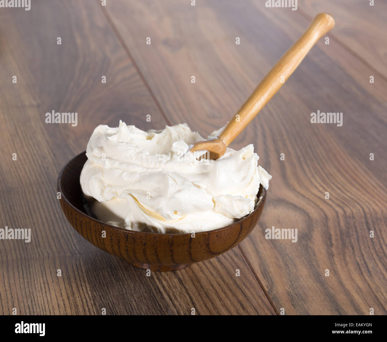 very thick rustic sour cream in a bowl and wooden spoon Stock Photo