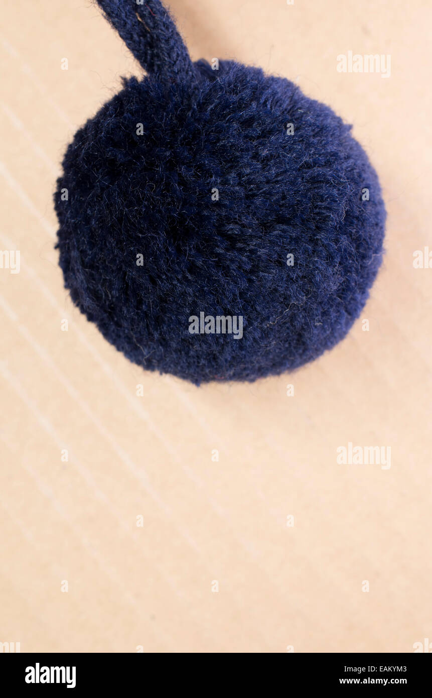 blue wool pom pom on a light brown surface Stock Photo