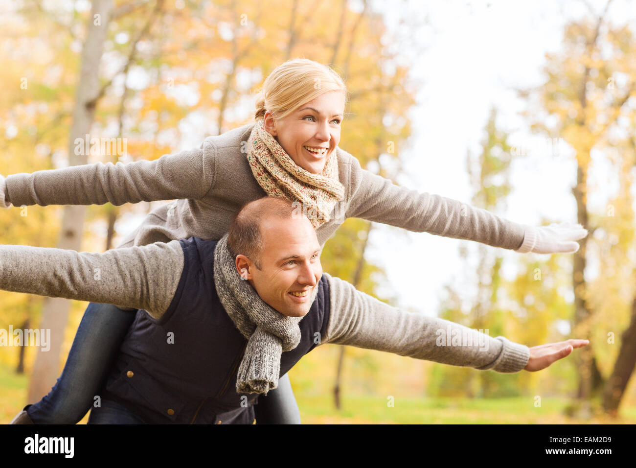 smiling couple having fun in autumn park Stock Photo - Alamy