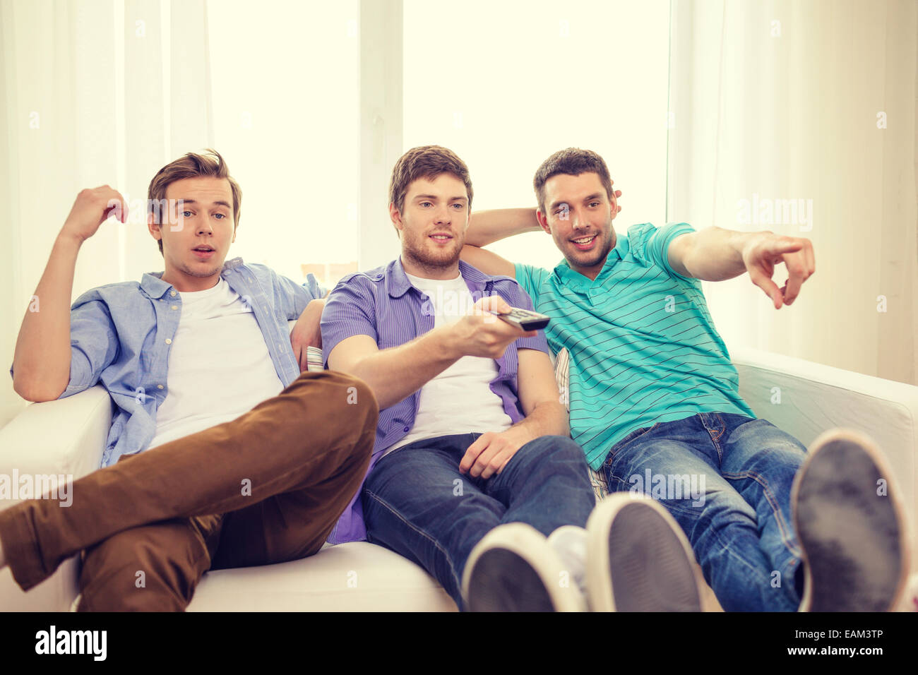smiling friends with remote control at home Stock Photo - Alamy