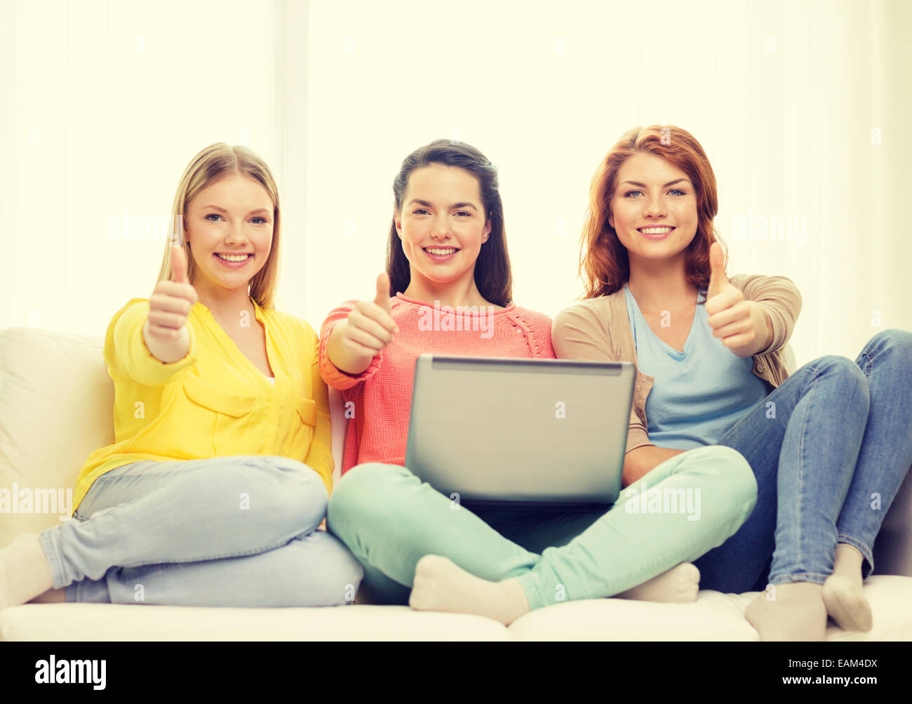 three smiling teenage girls with laptop at home Stock Photo - Alamy