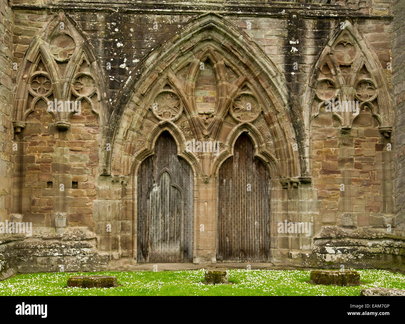 Spectacular doorway & wall of ruined 12th century Tintern abbey with ornate arches & decorative gothic style stonework Stock Photo