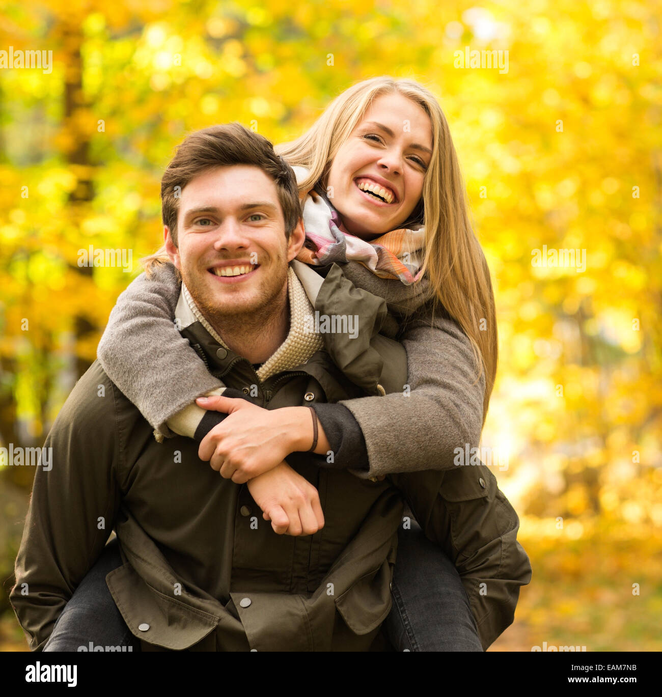 smiling couple having fun in autumn park Stock Photo - Alamy