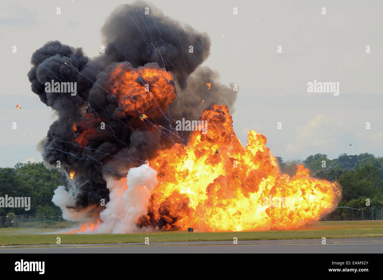 A pyrotechnic explosion on an airfield designed to illustrate a bomb attack. Fire and black smoke from ignition Stock Photo