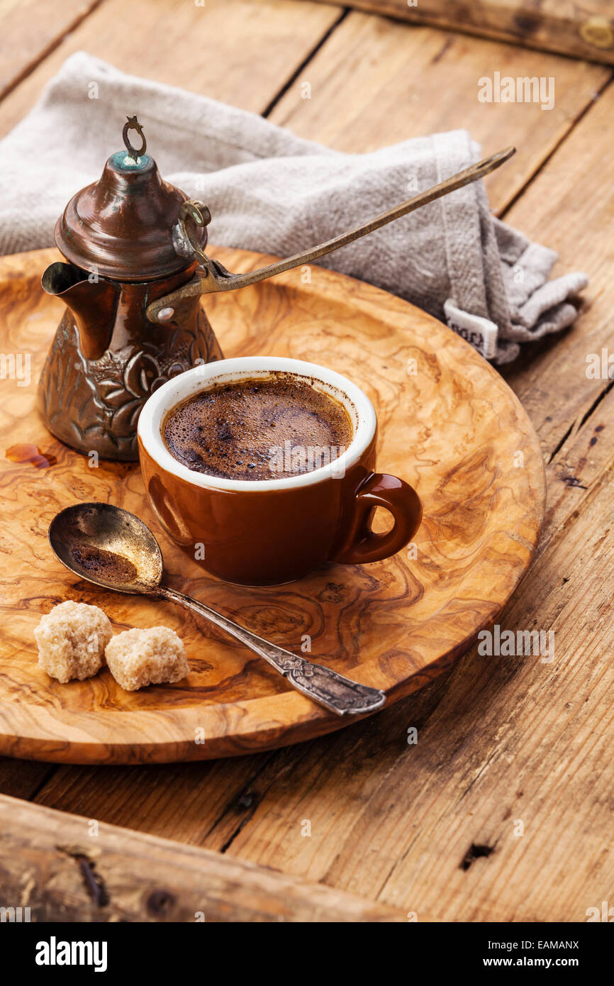 Cup of black coffee and Turkish Cezve on wooden background Stock Photo