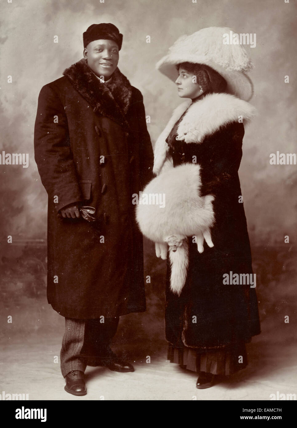 Jack Johnson and his wife Etta, full-length portrait, standing, wearing winter coats, circa 1910 Stock Photo