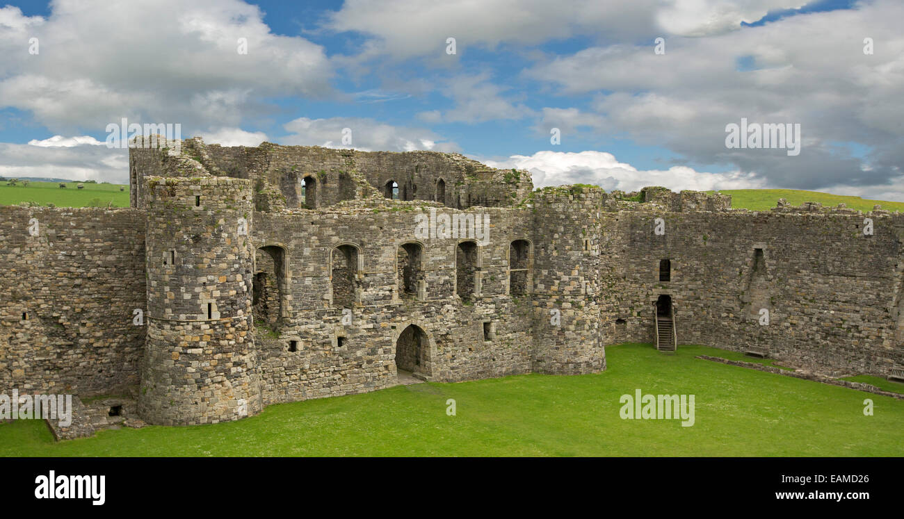 Interior of impressive Beaumaris castle with high towers & walls surrounding grassy courtyard under blue sky in Wales Stock Photo