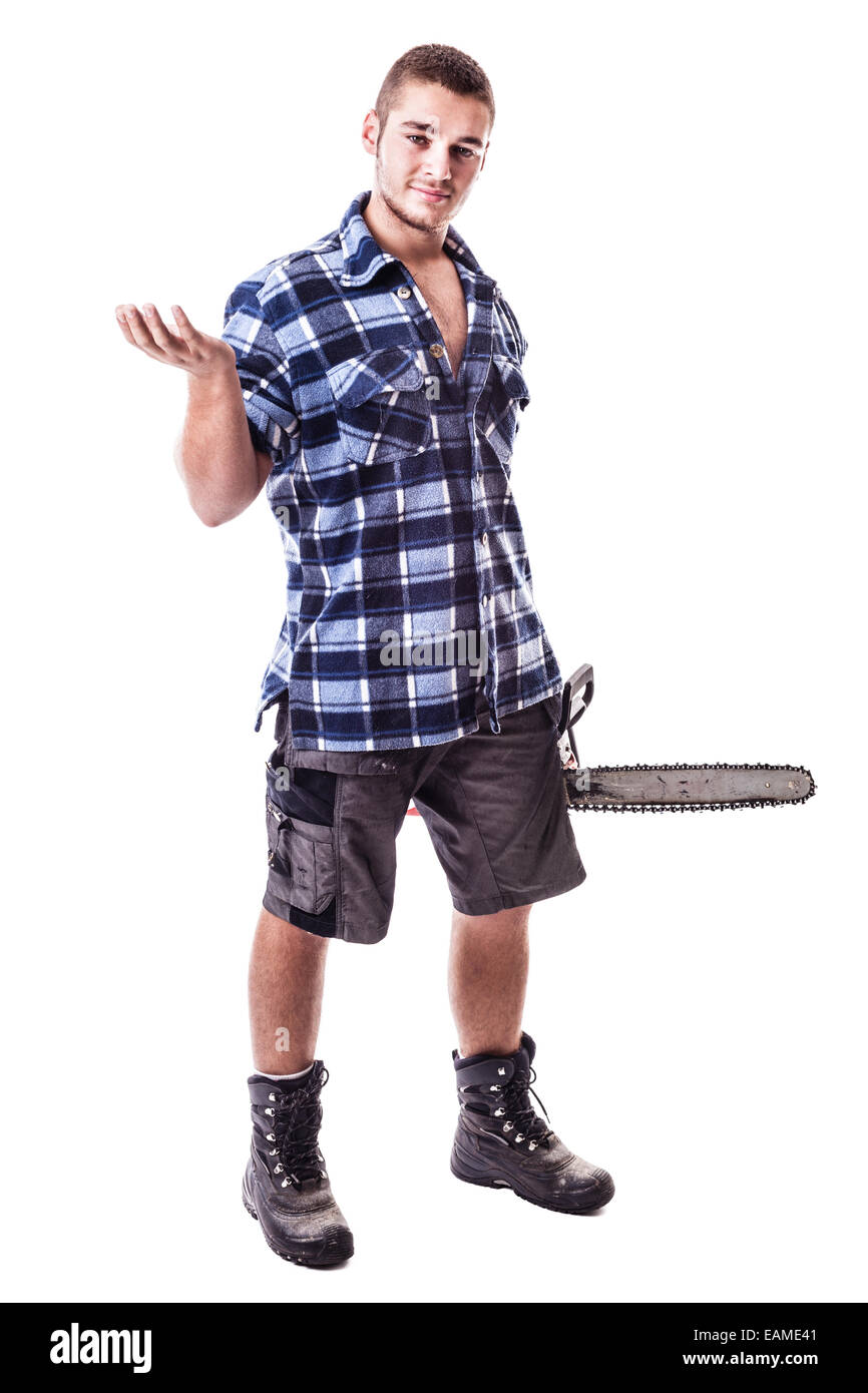 a young lumberjack wearing a checkered shirt holding a chainsaw and showing something isolated over white background Stock Photo
