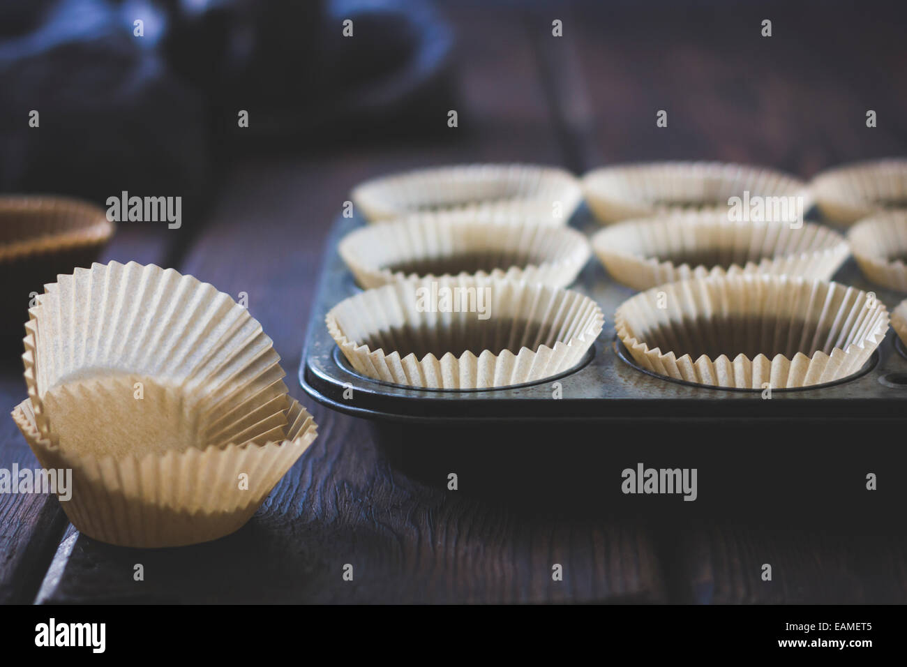 https://c8.alamy.com/comp/EAMET5/paper-muffin-cups-in-vintage-pan-EAMET5.jpg