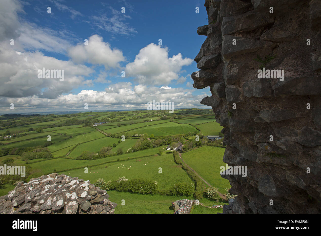 Spectacular view of vast emerald farmlands on rolling hills under blue sky from ruins of hilltop Carrig Cennen castle in Wales Stock Photo