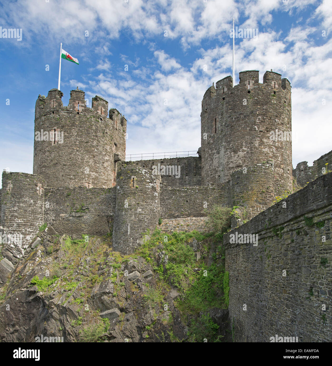 Magnificent 13th century Conwy castle in Wales with huge round towers spearing into blue sky streaked with clouds Stock Photo