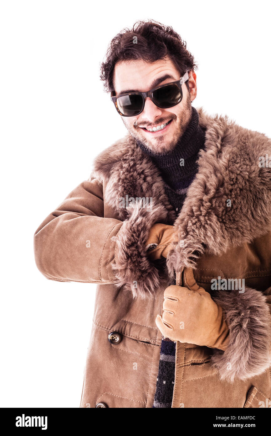 a cheerful young man wearing an expensive sheepskin furry coat isolated
