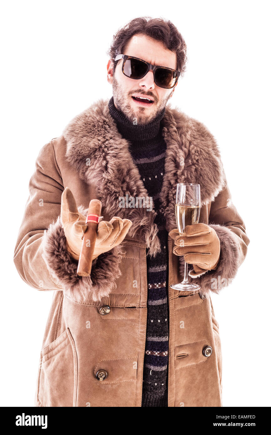 a young man wearing a sheepskin coat isolated over a white background holding a cigar and a glass with champagne Stock Photo