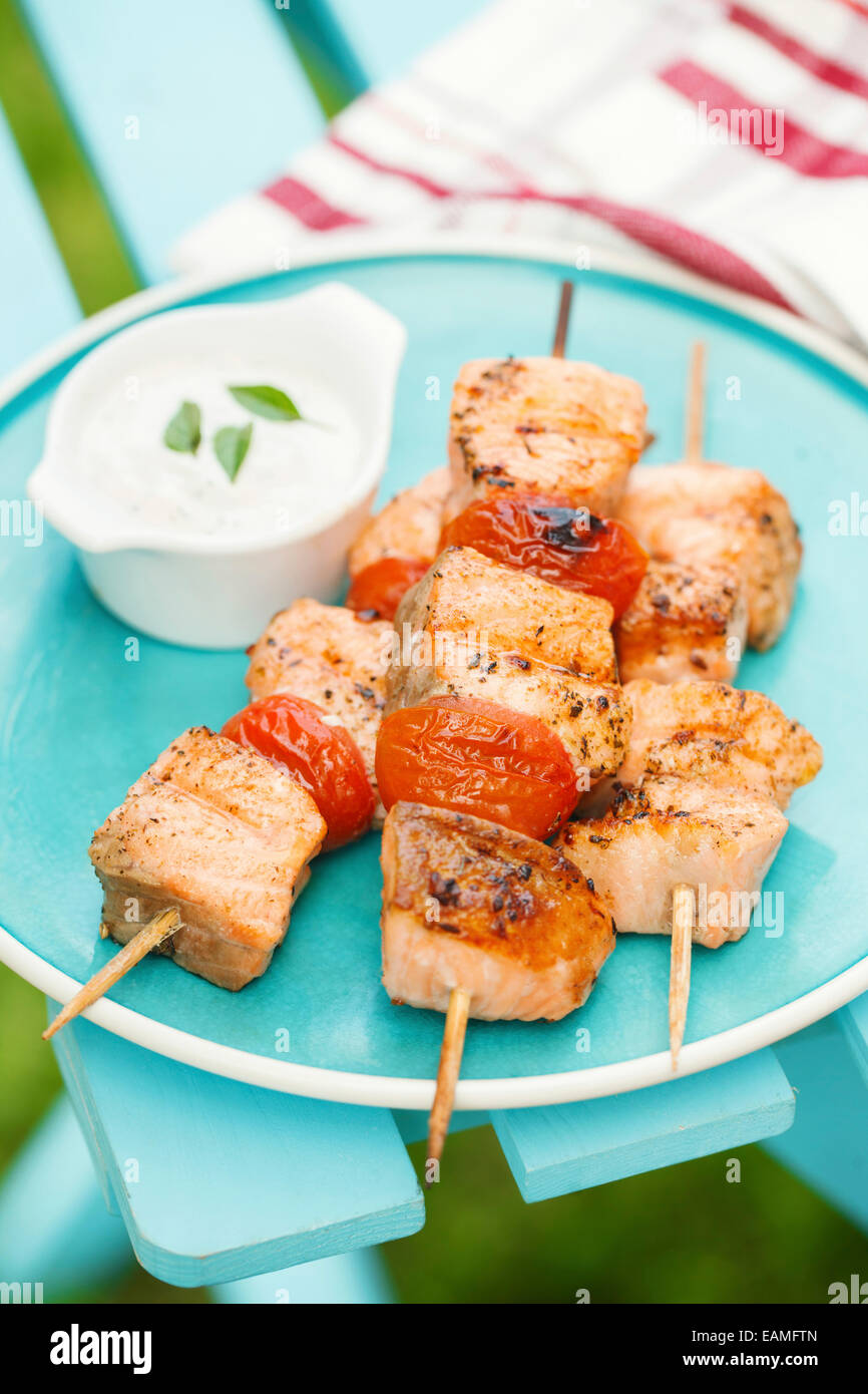 Grilled salmon kebabs with cherry tomatoes and garlic sauce Stock Photo