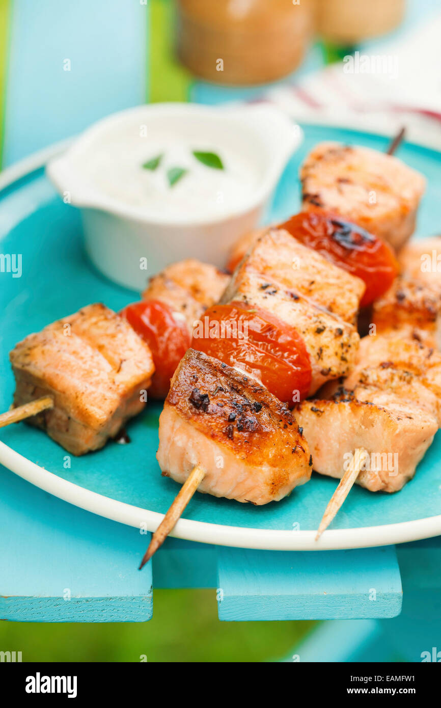 Grilled salmon kebabs with cherry tomatoes and garlic sauce Stock Photo