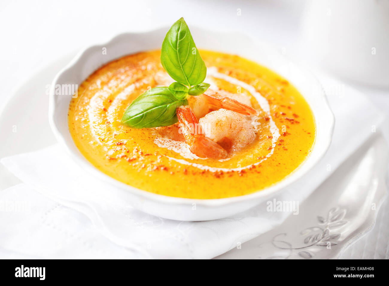 Pumpkin soup with shrimps and basil Stock Photo