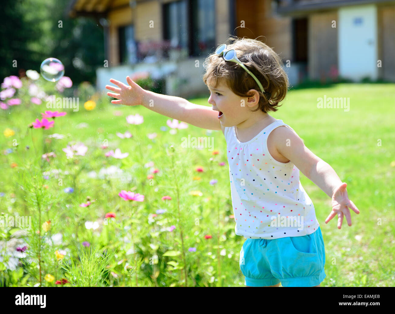 a little girl playing with soap bubbles in the garden Stock Photo - Alamy
