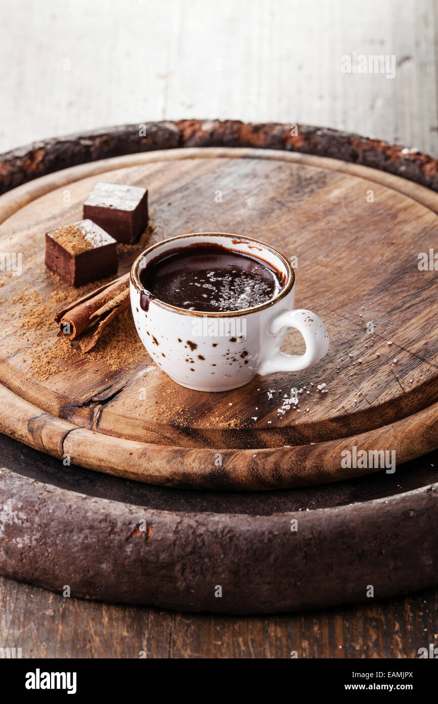Hot chocolate sprinkled with white chocolate and spices on dark wooden background Stock Photo