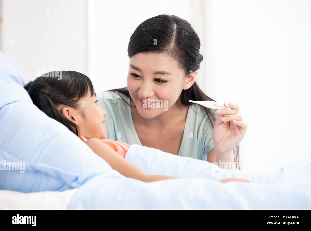 Mother is testing temperature for the daughter Stock Photo