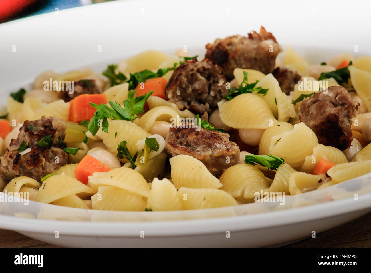 Hearty dinner of Italian sausage, white bean and shell pasta soup with homemade rye toast Stock