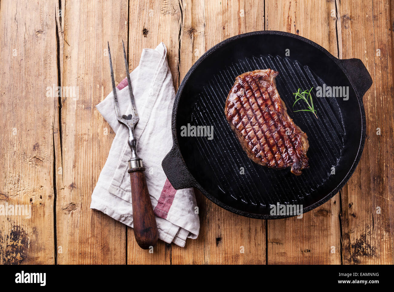 Grilled South American premium beef New York steak on grill pan on wooden background Stock Photo