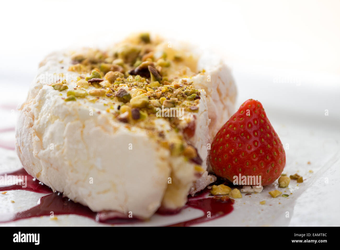 Meringue roulade with pistachio and raspberry coulis Stock Photo Alamy