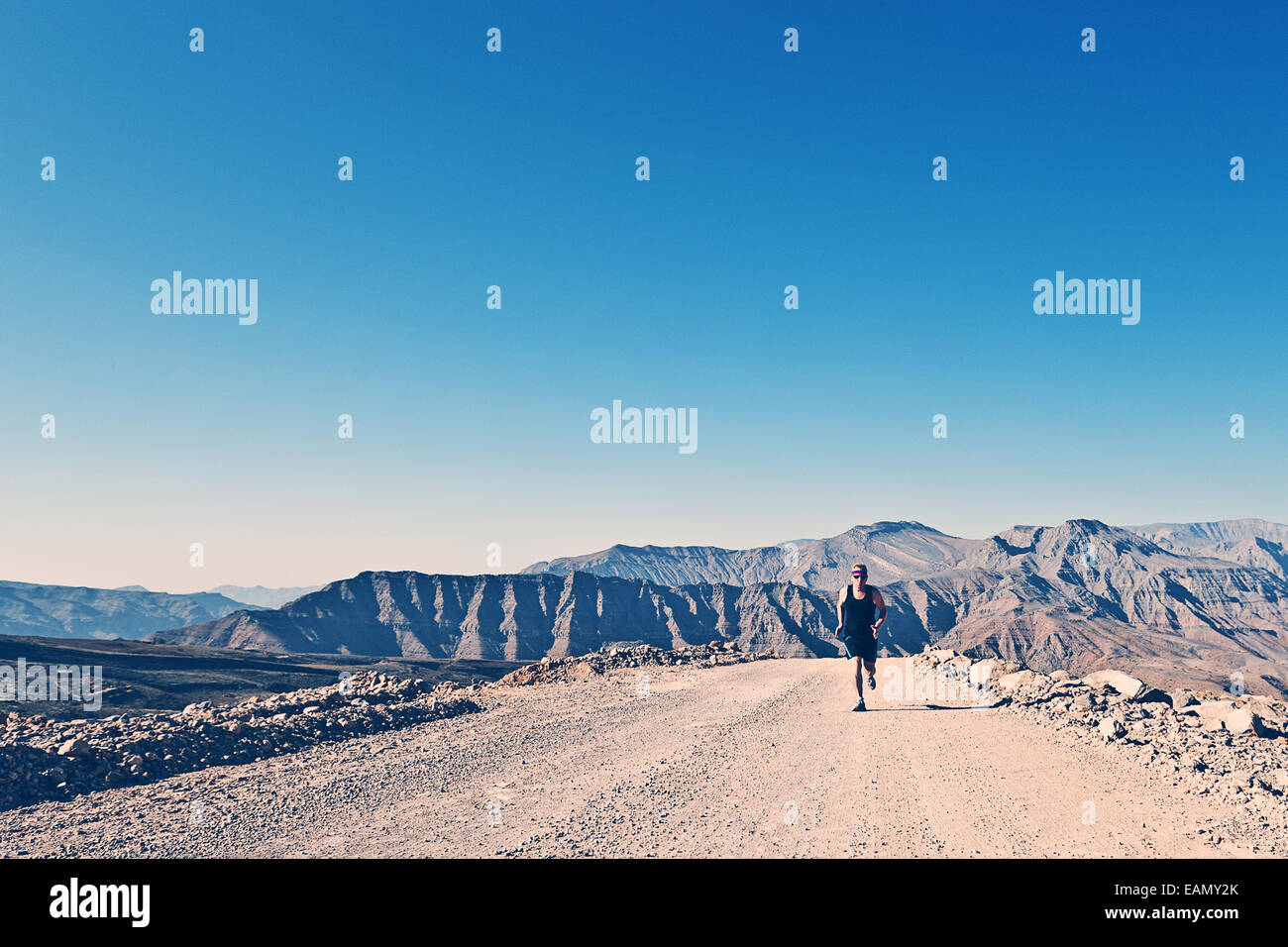 Shot of a Man Running on Mountain Road Stock Photo