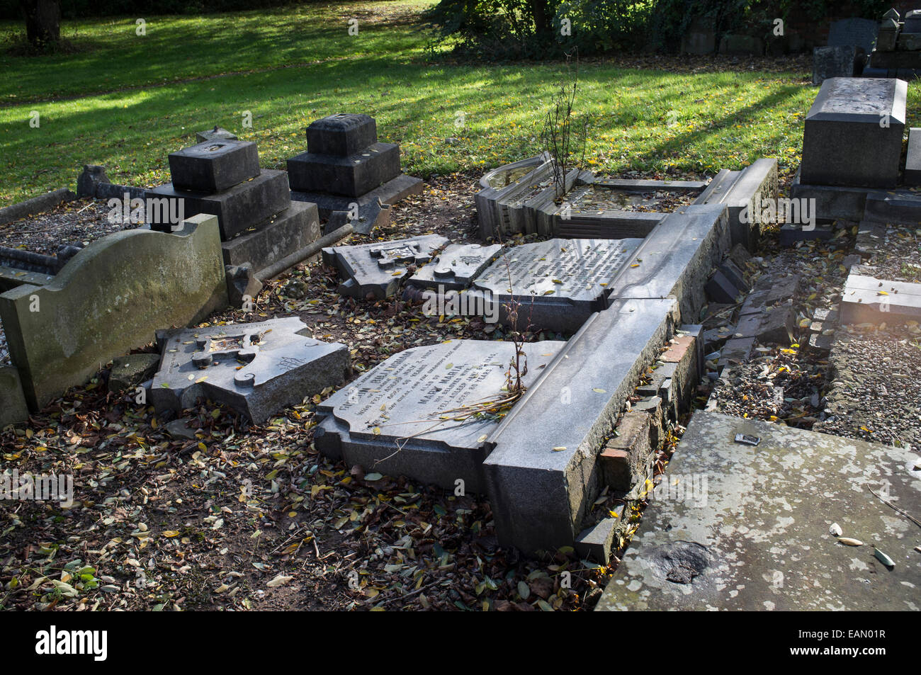 Broken headstones of vandalised graves in churchyard awaiting