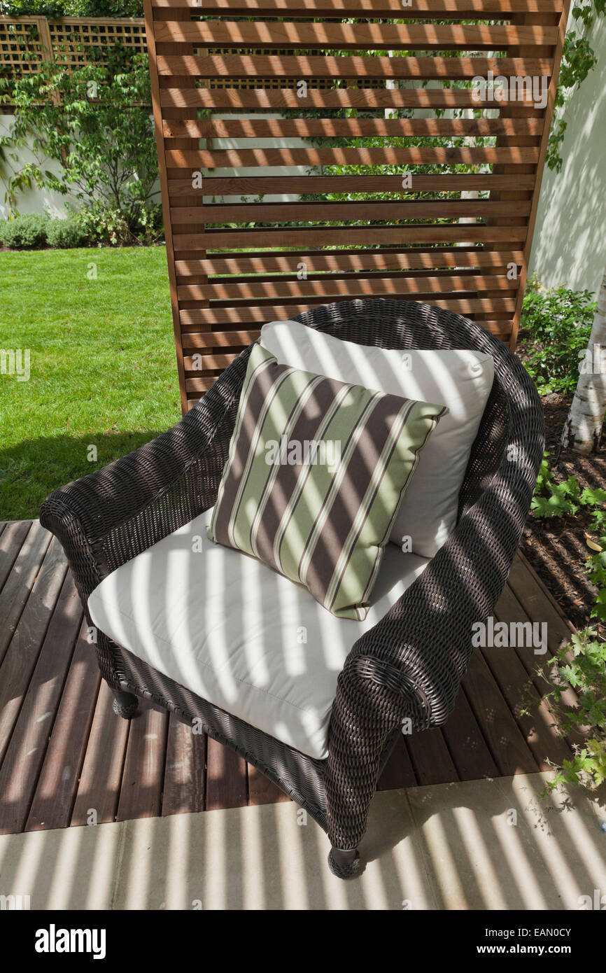 Colonial-style rattan furniture with striped cushions in the decked seating area in the slatted cedar pavilion Stock Photo