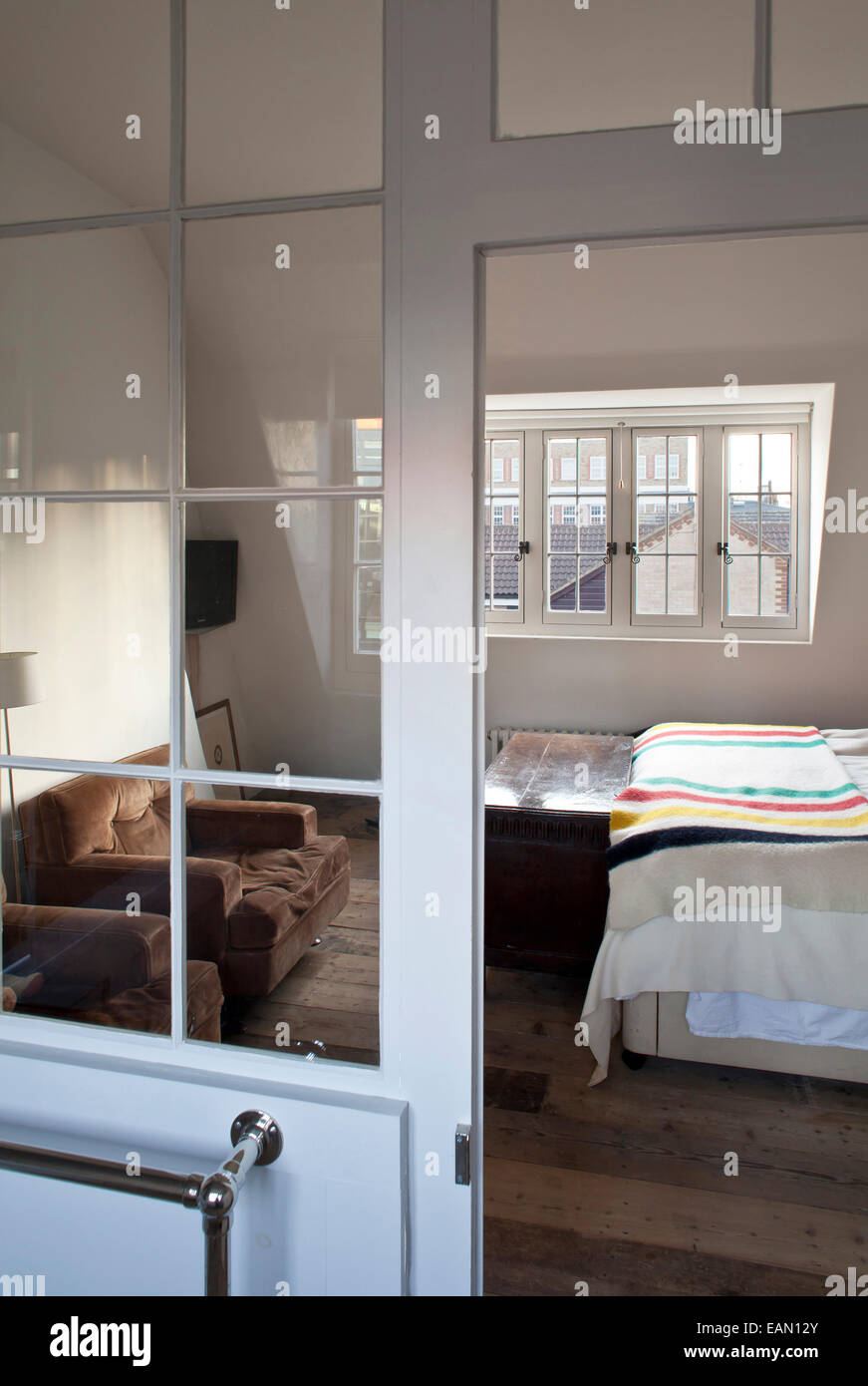 Double bed in attic room with sloping ceiling in Georgian town house, Whitechapel, London Stock Photo