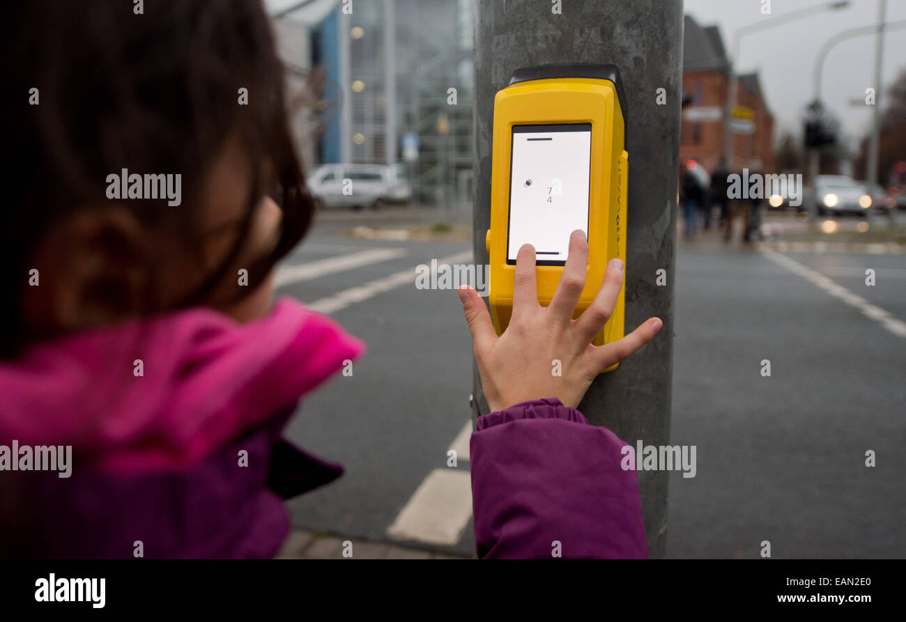 A girl plays with the Streetpong traffic light in Hildesheim, Germany, 18 November 2014. Two students from the University of Applied Sciences and Arts (HAWK) in Hildesheim have developed a game intended to fight boredom at traffic lights. With the 'Pong' videogame, pedestrians can play to pass the time while they wait for the light to change. Photo. JULIAN STRATENSCHULTE/dpa Stock Photo
