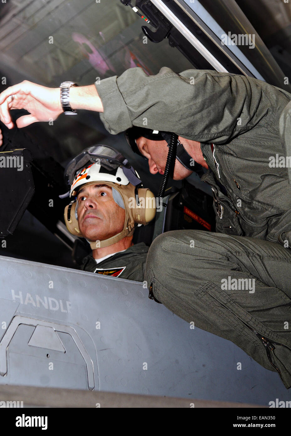 Texas Governor Rick Perry is briefed in the cockpit of an F/A-18F Super Hornet fighter aircraft in the hangar bay of the aircraft carrier USS Ronald Reagan prior to his flight February 4, 2011 in the Pacific Ocean. Stock Photo