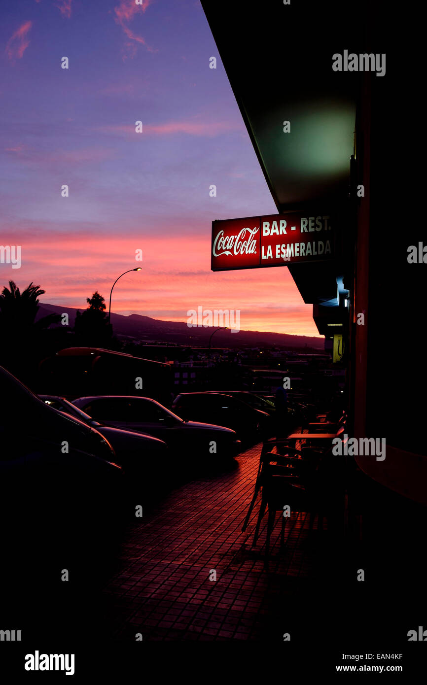 Red sky at dawn with Coca Cola sign on the Bar La Esmeralda, Playa San Juan, Tenerife, Canary Islands, Spain. Stock Photo