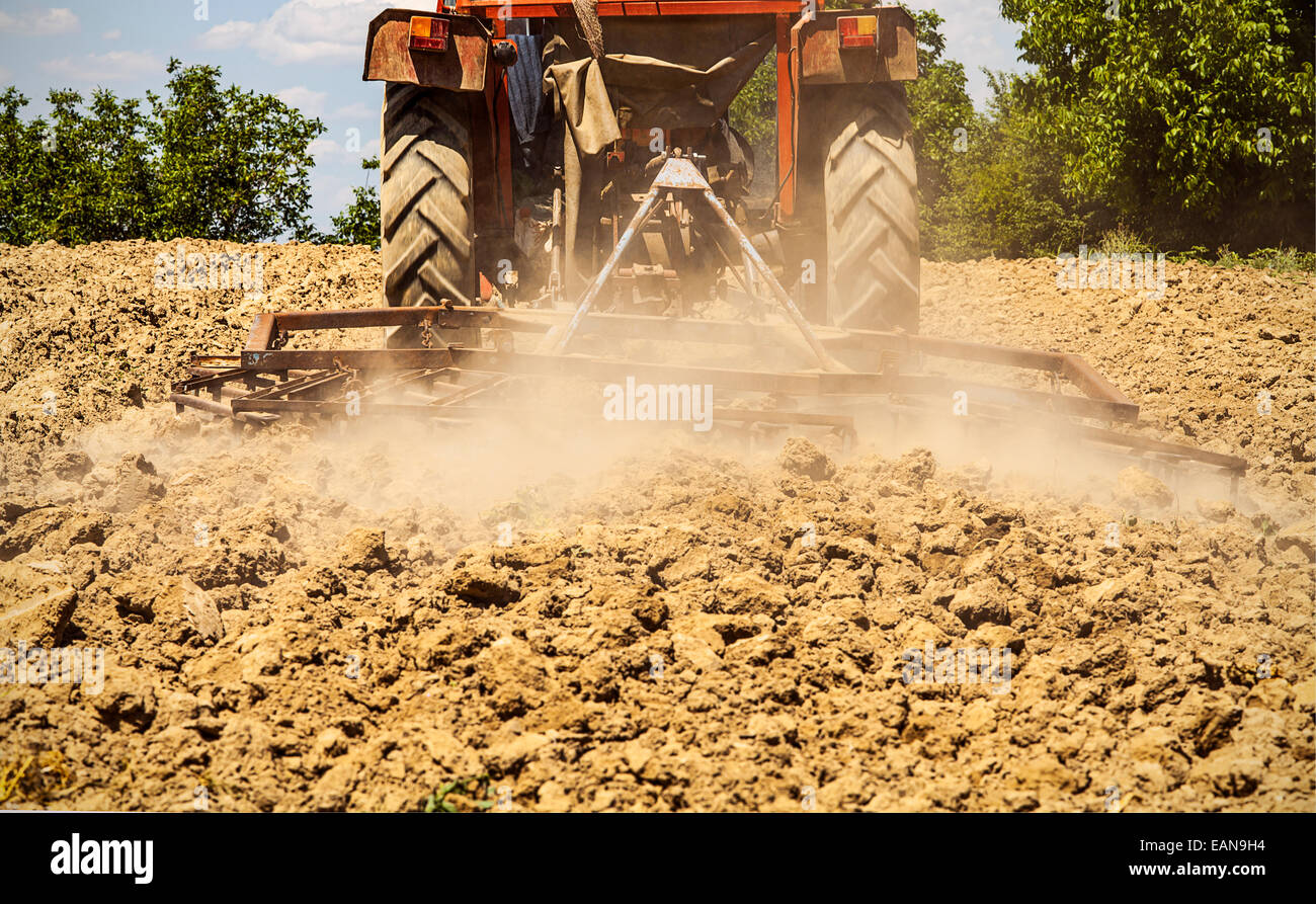 Tractor harrowing the land Stock Photo Alamy