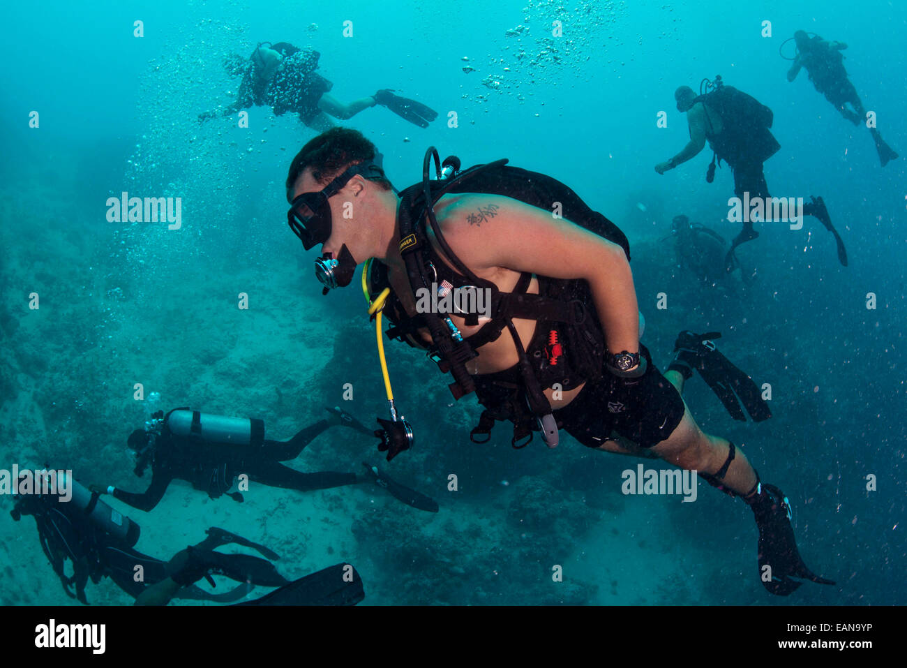 US Navy divers dive alongside Belize Coast Guard Service divers during a joint training dive at the famous Blue Hole July 11, 2014 in Belize. Stock Photo