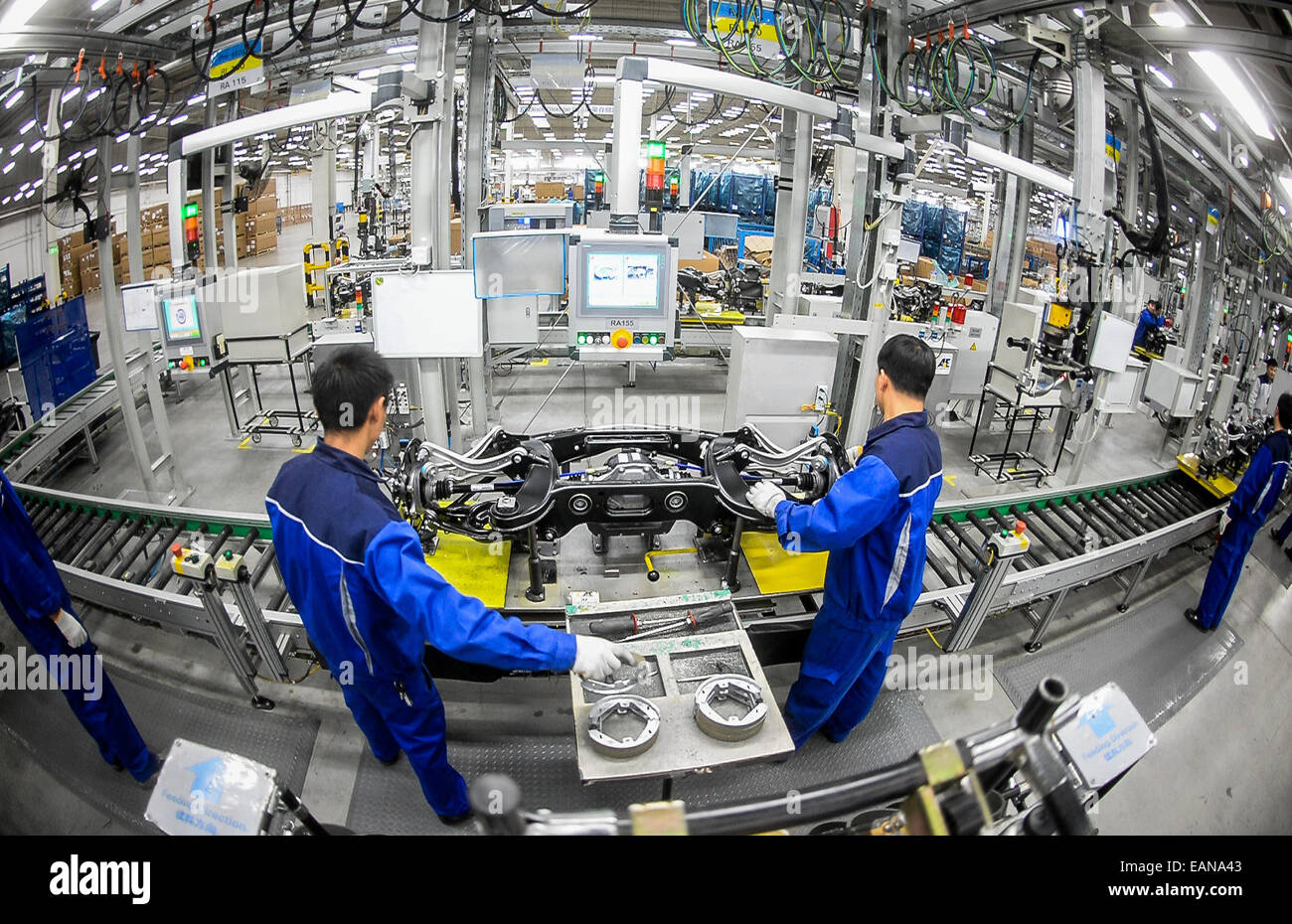 Workers assemble undercarriage components on a front wheel axle for Mercedes in the ZF Chassis Systems factory in Peking, China, 14 November 2014. At the automotive supply factory, axles for Merecedes C- and E-Class cars are assembled. Members of Lower Saxon Premier Weil's economic delegation visited the factory in Peking. Weil traveled through China with representatives from the economy, science, and politics  from 09-15 November 2014. Photo: Ole Spata/dpa Stock Photo