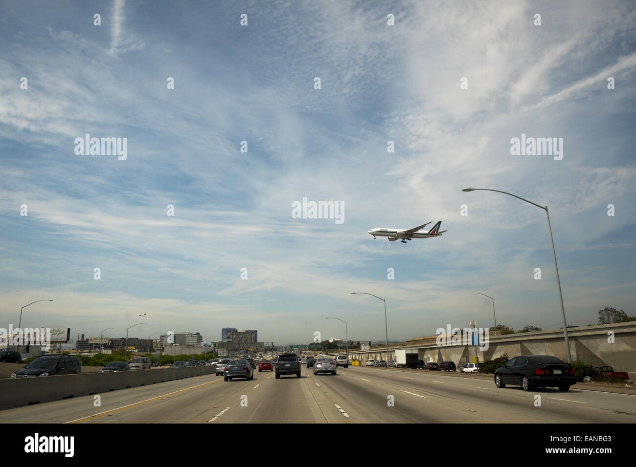 Traffic in Los Angeles California with a Jet Liner landing at LAX Airport over road Stock Photo